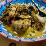 Creamy Chicken served on a plate with bread aside on a wooden board